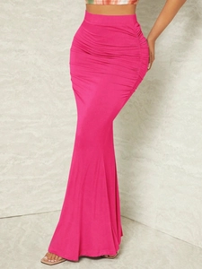 Détail d'une jupe sirène froncée à taille haute en tissu tricoté élastique rose
