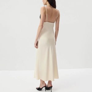 Detail of champagne satin midi dress featuring black lace patchwork and backless design
