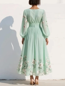 Back view of mint green floral maxi dress with long sleeves and pleated waist detail