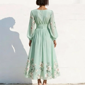 Back view of a long-sleeved floral mint green maxi dress with pleated waist and flowy hem