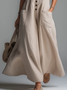 Detail of loose-fit beige linen dress with resin buttons and large front pockets