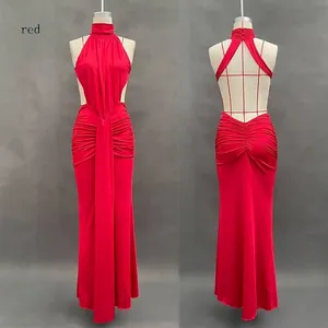 Detail of red halter neck dress featuring ruched fabric and backless criss-cross straps