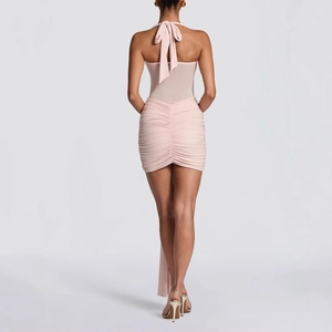 Détail du dos d'une robe dos nu rose clair avec maille froncée et liens à nouer