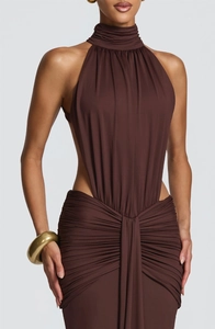 Close-up of ruched detail and side cutout on dark brown halter neck maxi dress