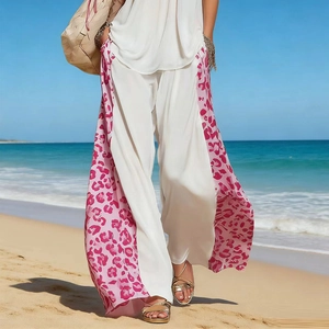 Close-up of white wide-leg pants featuring pink leopard print panels and side pockets