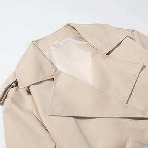 Dettaglio trench beige con ampi revers, spalline e fodera in raso dalla finitura lucida