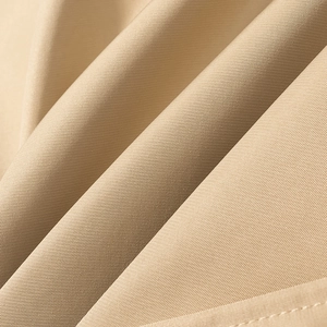 Dettaglio del tessuto in twill beige chiaro e delle cuciture pulite sulla giacca corta