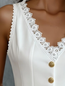 Détail du décolleté en V avec dentelle blanche et boutons dorés gaufrés sur haut satin