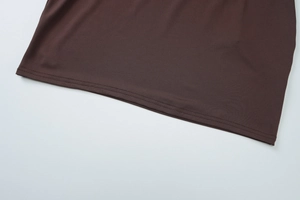 Macro view of double-needle hem stitching on chocolate brown knit halter dress