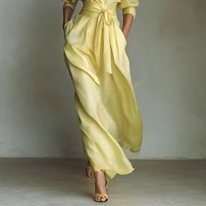 Detail of waist wrap design and pleated silky fabric on a lemon yellow maxi dress