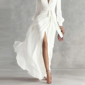 Close-up of white wrap chiffon maxi dress showing the flowing high-slit and soft fabric texture