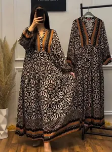 Detail of V-neck floral kaftan maxi dress with ethnic patterns and orange trim accents