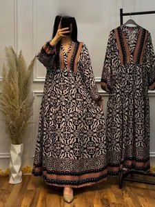 Detail of V-neck floral maxi dress with geometric patterns and orange trim accents