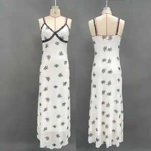 Detail of V-neck lace trim and black floral print on a milky white summer dress