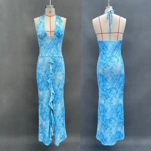 Detailed view of backless halter dress featuring blue abstract print and ruffle slit