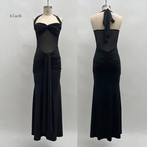 Détail de robe noire dos nu montrant la texture en tulle froncé et les longs liens de cou