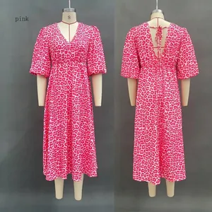 Dettaglio dell'abito leopardato rosa con profondo scollo a V e maniche a sbuffo