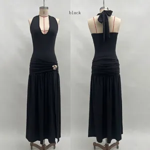 Detail view of black halter dress featuring side ruching and silver flower buckle