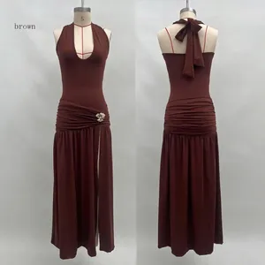 Detail of coffee brown halter maxi dress featuring ruching and gold flower buckle detail