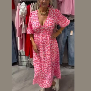 Dettaglio di un abito lungo con stampa leopardata rosa, scollo a V e maniche a sbuffo