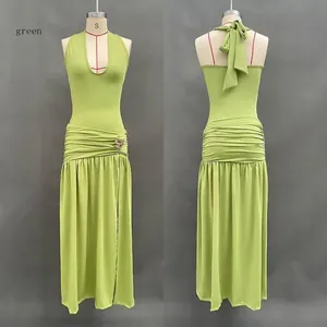 Detail of green halter neck dress with waist ruching and side slit on mannequin