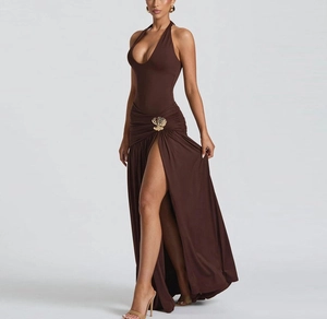 Detail of brown halter maxi dress featuring a deep V-neck and golden shell buckle ornament