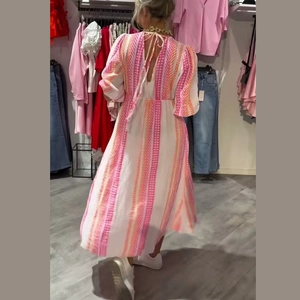 Dettaglio del design con schiena scoperta e lacci e trama intrecciata sull'abito bianco