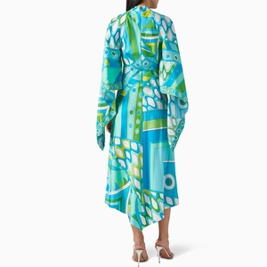 Back view of a long-sleeved dress with vibrant geometric prints and unique split cape sleeves