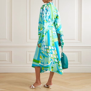Detail of loose long sleeve dress featuring vibrant geometric prints and asymmetric hemline