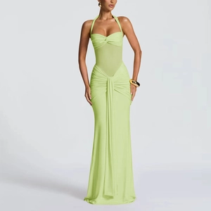 Détail de la texture froncée et du drapé latéral sur une robe longue dos nu vert clair