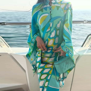 Detailed close-up of a printed maxi dress featuring a high neck and geometric wave patterns