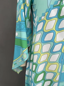 Close-up of geometric wave print dress featuring vibrant blue and yellow flare sleeves