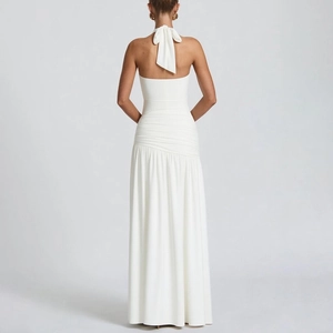 Detail of white halter neck maxi dress with ruched waist and tie-back bow design