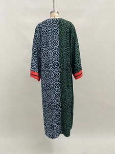Detail of V-neck maxi dress featuring asymmetric color-block patterns and red cuffs