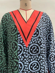 Detailed view of the V-neckline and vibrant geometric print on this long sleeve dress