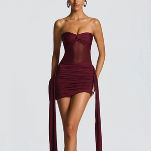 Detail of burgundy mesh paneling and side ribbons on this strapless party dress