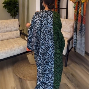 Detail of a kaftan dress featuring color-blocked totem prints and wide batwing sleeves