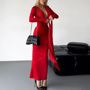 Detail of red deep V-neck bodycon dress with long streamers and silky fabric texture