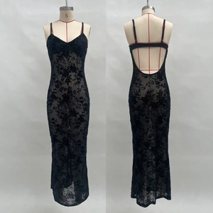 Détails de la robe longue en dentelle noire avec motifs floraux en velours et dos nu