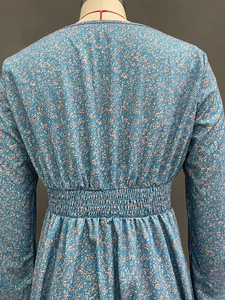 Close-up of the elastic smocked waist and floral pattern on this blue midi dress