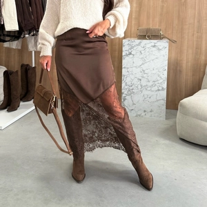 Détail d'une jupe en satin marron avec dentelle florale et ourlet asymétrique chic