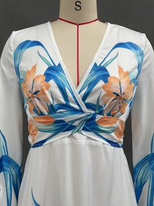 Detail eines V-Ausschnitt Kleides mit blauen Blättern und orangefarbenen Blumen