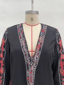 Nahaufnahme von V-Ausschnitt Langarm-Top mit roten Blumenprints und Ethno-Mustern