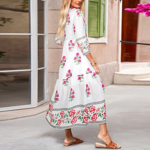 Détail de robe longue bohème blanche à imprimé floral avec jupe à plusieurs niveaux
