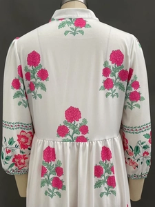 Détail de l'imprimé floral pivoine rose au dos d'une robe trapèze blanche à manches