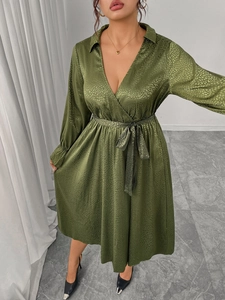 Detail of olive green satin V-neck dress showing jacquard animal pattern and waist tie