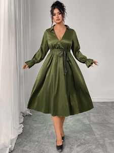 Detail of dark green leopard print satin dress with V-neck wrap design and waist tie