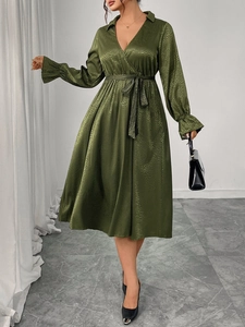 Detail of olive green satin jacquard fabric with elegant V-neck and tie-waist design