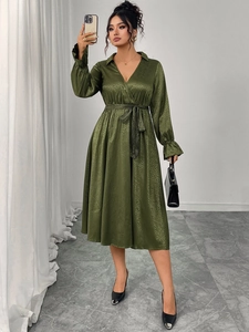 Detail view of olive green satin V-neck dress featuring tie waist and puff sleeves