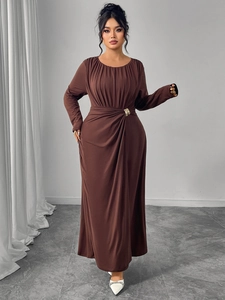 Detail of waist pleats and gold ring buckle on a brown long-sleeved maxi dress